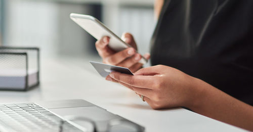 Midsection of woman using mobile phone