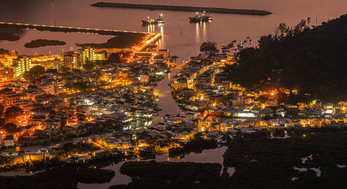 Illuminated buildings against sky at night