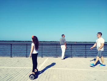 Full length of woman standing on sea against clear sky