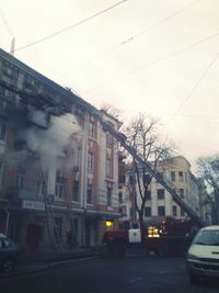 Cars on road in city against sky