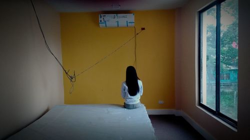 Full length of woman hanging on wall at home