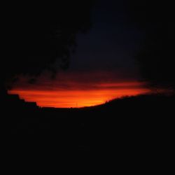 Silhouette landscape against sky at sunset