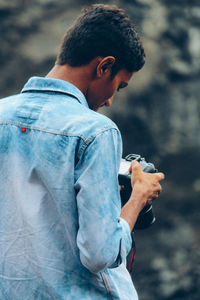 Close-up of young man holding camera