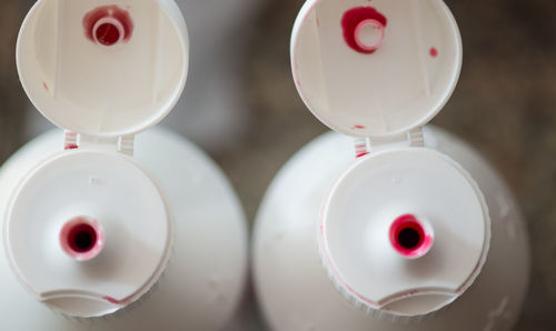 Close-up high angle view of plastic bottles with open lids