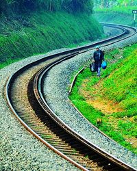 High angle view of man sitting on railroad track