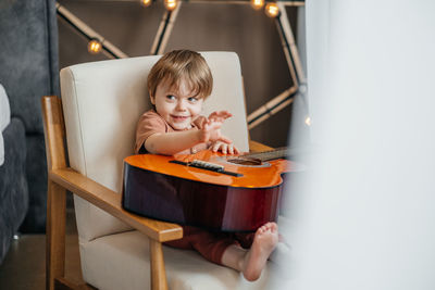 Little boy playing classical guitar. high quality photo