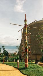 Traditional windmill on field against sky in park