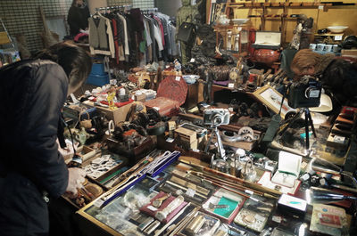 People looking at various objects in old market stall