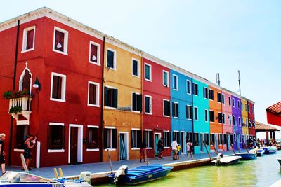 Boats in canal by building against sky