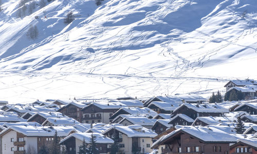 Snow covered houses and buildings against sky