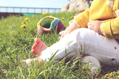 Low section of child sitting on field