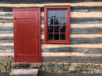 Red door and window of historic pennsylvania log cabin