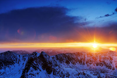 Scenic view of snow mountains against sky during sunset