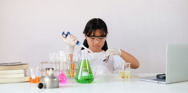 Girl doing experiment against white background