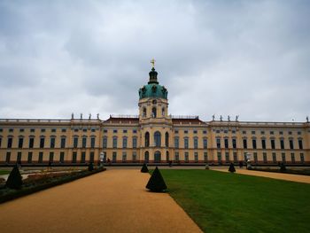 Facade of historic building against cloudy sky