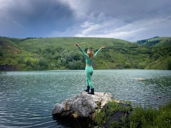 Rear view of man standing by lake