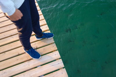 Low section of man standing on jetty