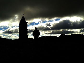 Silhouette people against cloudy sky