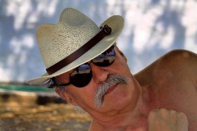 Close-up of mature man wearing hat and sunglasses