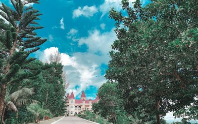 Low angle view of trees and buildings against sky