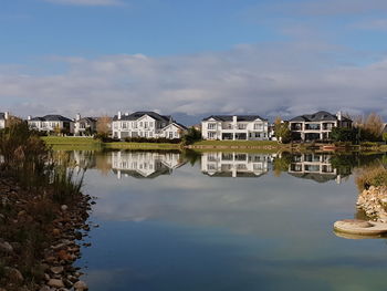 Reflection of buildings in lake against sky