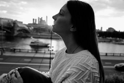 Portrait of young woman looking away against sky