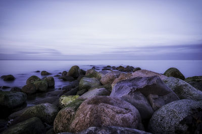 Rocks on sea shore against sky