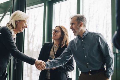 Mature businessman greeting senior colleague in meeting at office