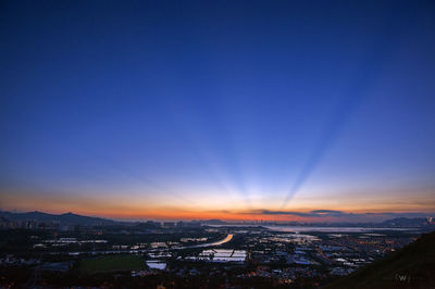 High angle view of buildings against blue sky at sunset