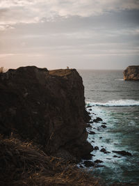 Rock formation on sea against sky