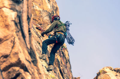 A mountaineer rappelling down the rock