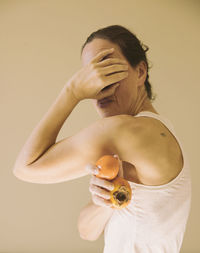 Woman with a persimmon and a tangerine in her hand ii