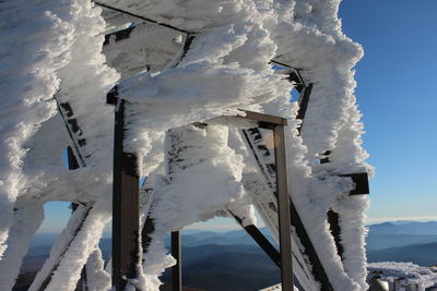 Icicles on snow covered mountain against sky