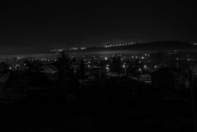 Illuminated city against sky at night