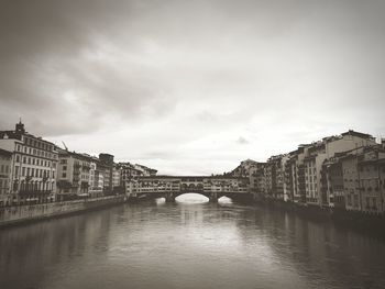 Bridge over river against buildings in city