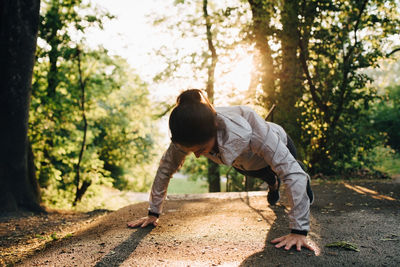 Young female athlete doing push-ups in park