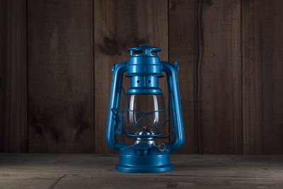 Close-up of blue lantern on wooden table
