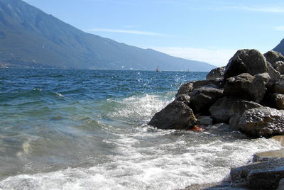 Scenic view of sea and mountains against sky