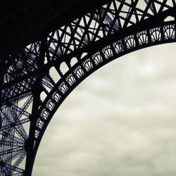 Low angle view of eiffel tower against cloudy sky