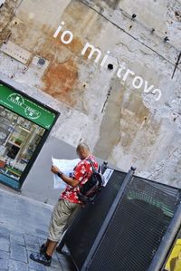 High angle view of man sitting on wall