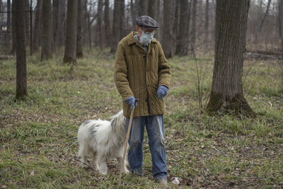 Full length of man with dog in forest