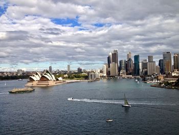 Expansive view of sydney harbor, sydney skyline, and the opera house, taken from the harbor bridge.