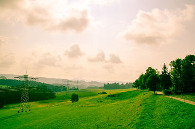 Scenic view of grassy field against cloudy sky