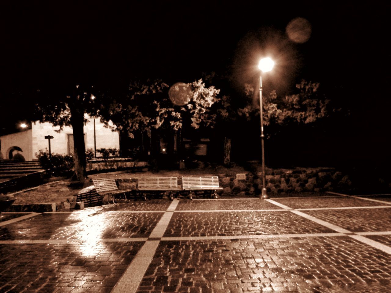 ILLUMINATED STREET BY SWIMMING POOL IN CITY AT NIGHT