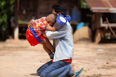 Cheerful of father and son practicing boxing on field