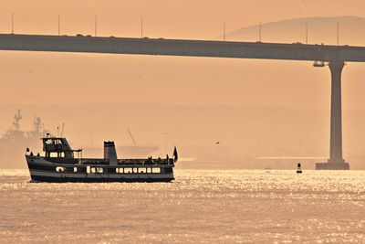 Boats on river during sunset