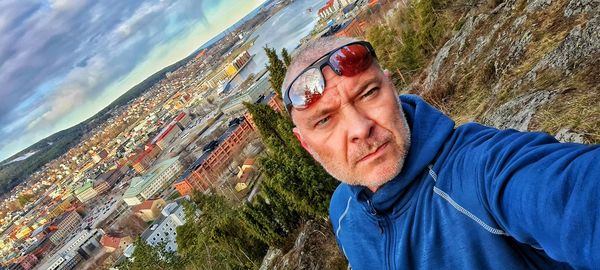 Portrait of man in city against sky