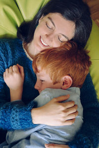 Directly above shot of mother and son sleeping on bean bag