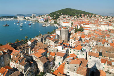 High angle view of townscape by sea against sky