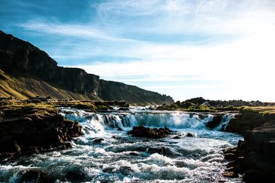 Scenic view of waterfall against sky